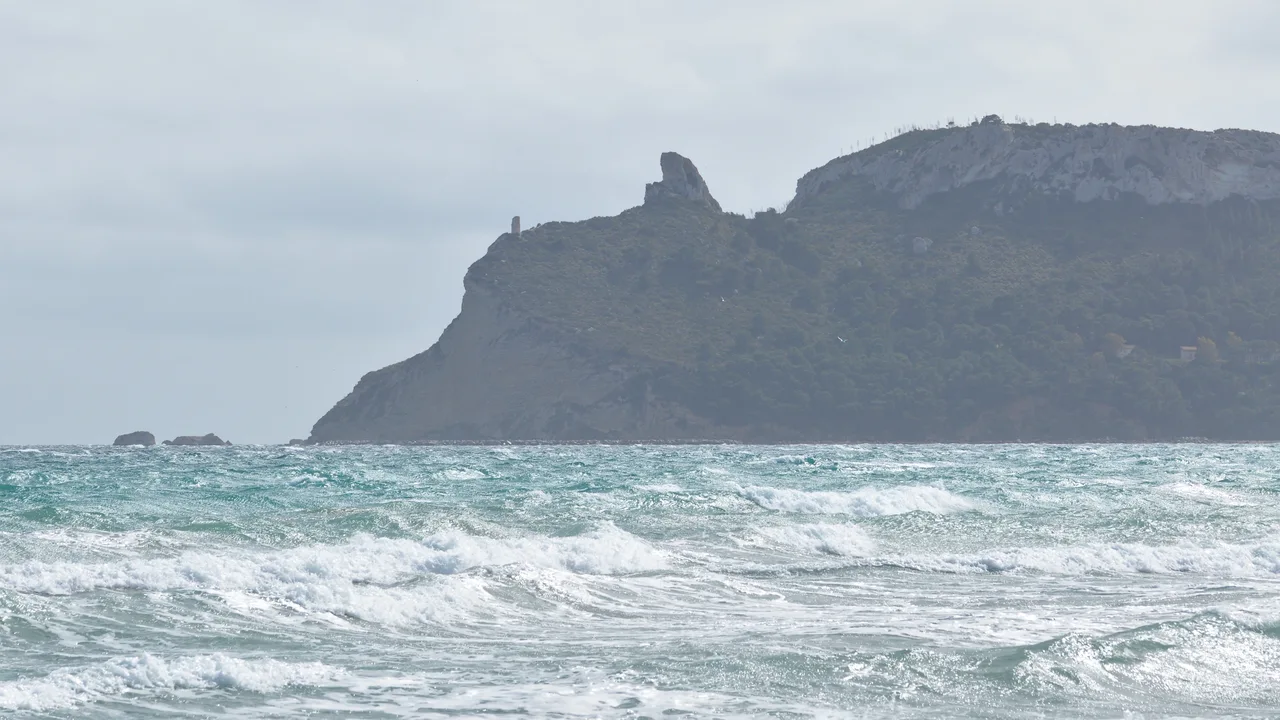 La Sella del Diavolo vista dal mare a Cagliari, con il profilo roccioso e le onde in primo piano